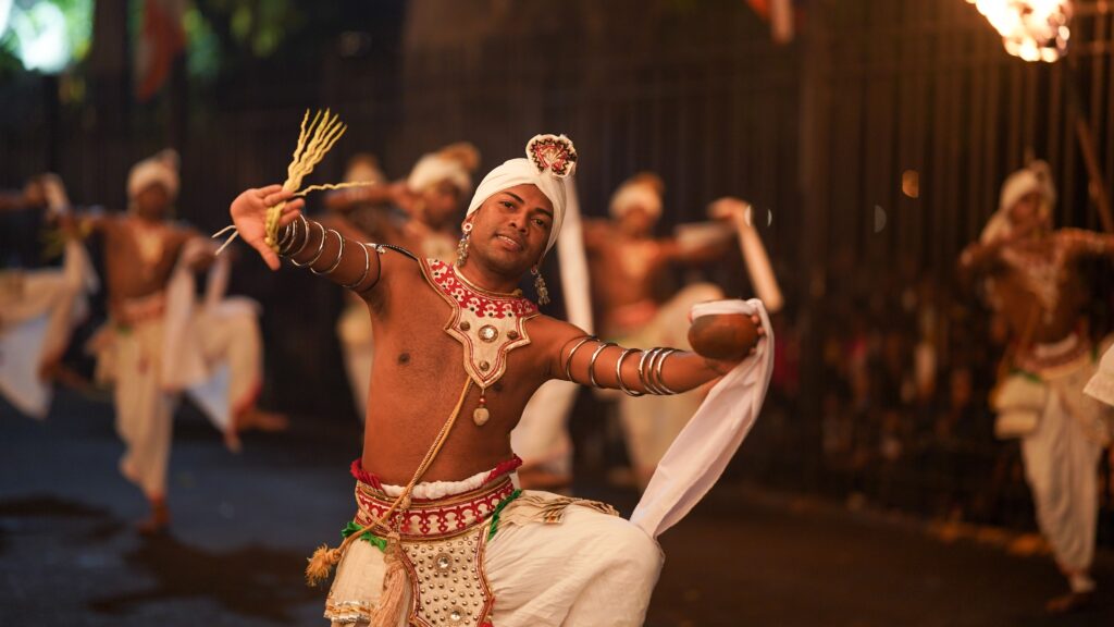 A traditional Kandyan dancer in full cultural attire performing at the Kandy Esala Perahera festival.