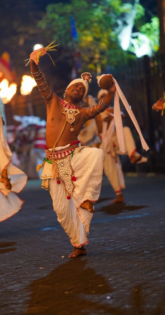 A traditional Kandyan dancer in full cultural attire performing at the Kandy Esala Perahera festival.