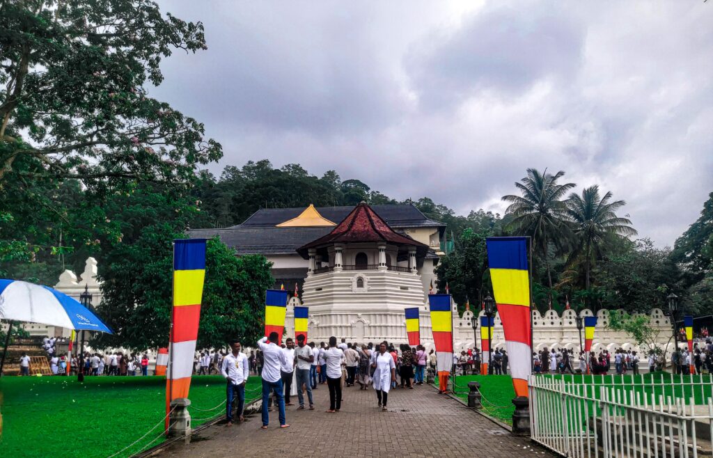 Exterior view of the Sacred Temple of the Tooth decorated with Buddhist flags in Kandy, Sri Lanka.